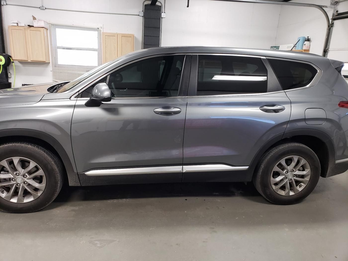 Gray Hyundai Santa Fe with tinted windows, side view in the shop
