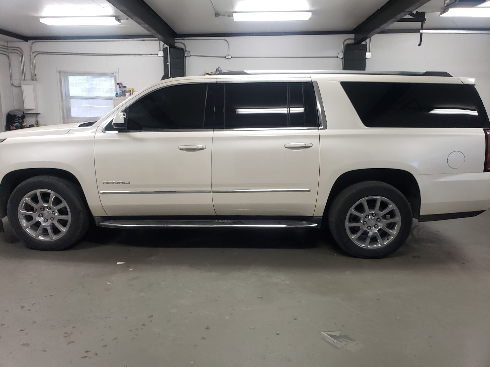 White GMC Yukon Denali XL with dark window tint in the D&R shop